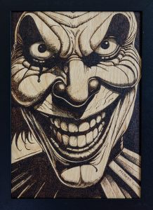 Moody yyrography of a scary clown grinning maniacally